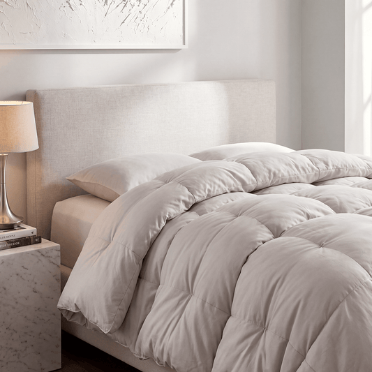 Light-colored quilted comforter with circular tufting, arranged on a bed