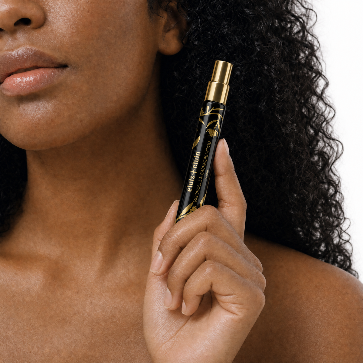 Patchouli and Cashmere Wood perfume bottle held in hand near face