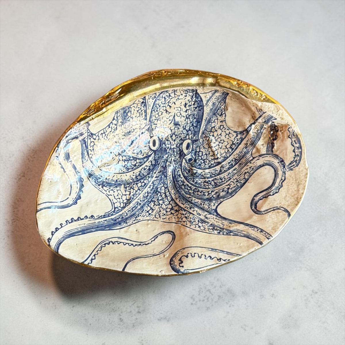Blue-and-white whale-like sea creature shell trinket dish with gold rim