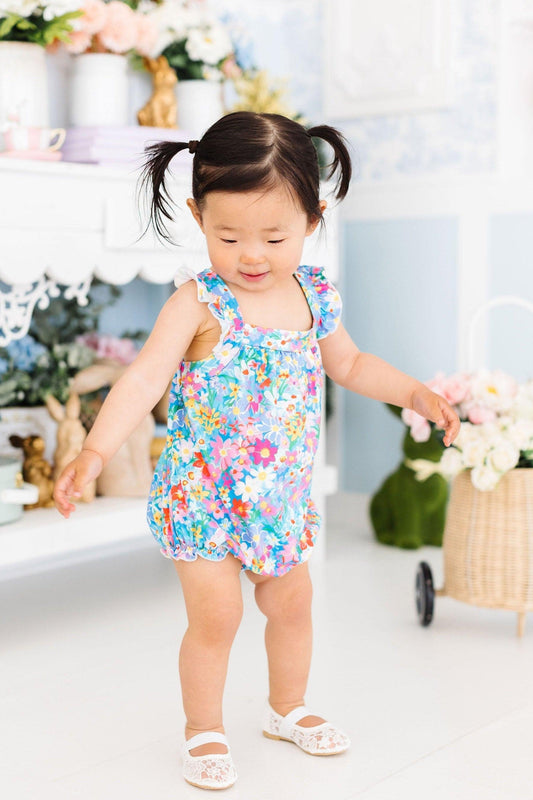 Multicolor floral cross-back romper with ruffled sleeves, worn by child