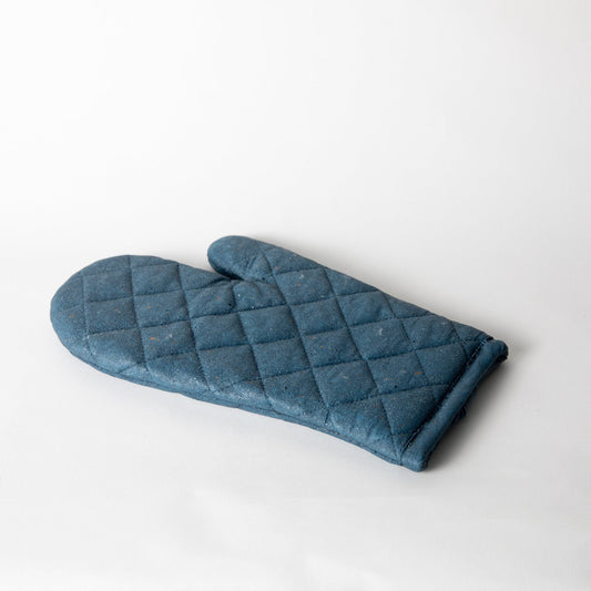 Cobalt blue quilted oven mitt trivet, folded with diamond stitching.