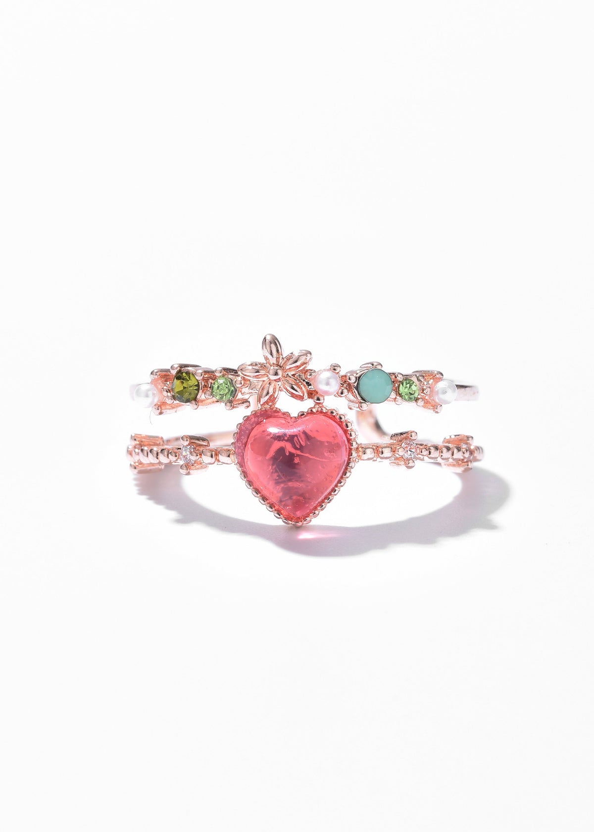 Stacked silver-tone rings with a large pink heart gem, colorful stones, and pearl accents