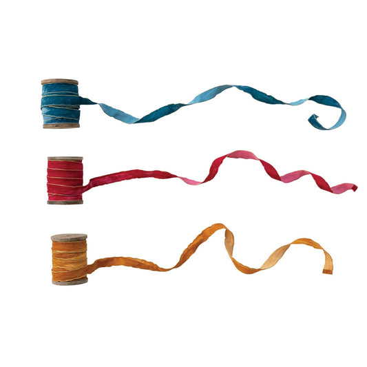 Velvet ribbon on spools, teal, burgundy, and orange lengths with metallic gold edges