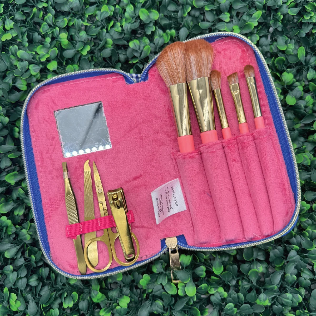 Open pink manicure brush kit with gold tools and brushes in pouch