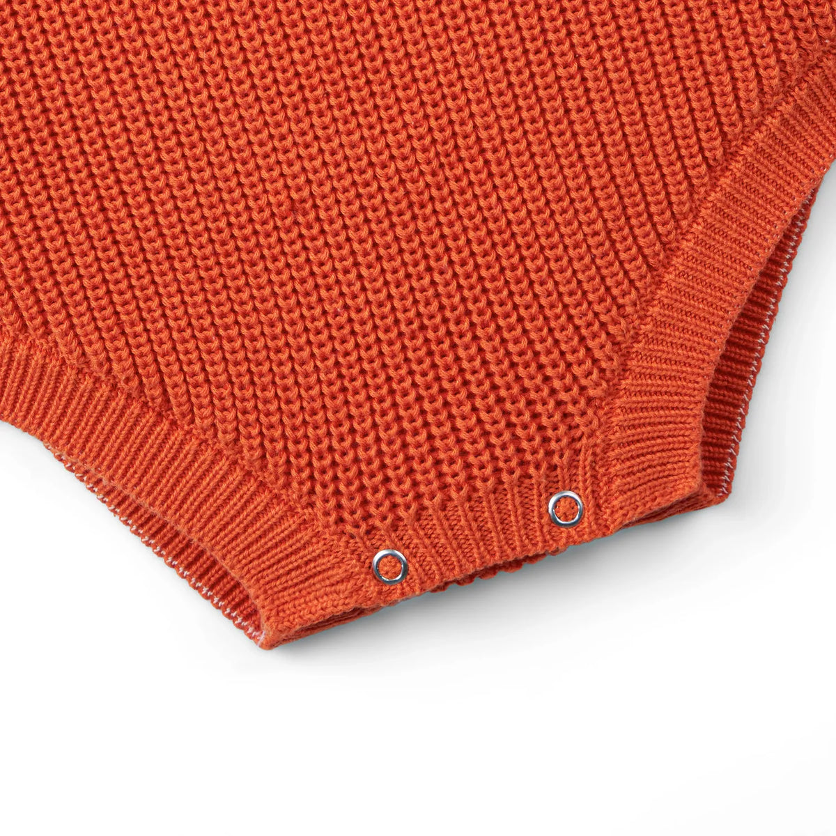 Orange rust chunky knit baby romper hem with two snap buttons at the bottom