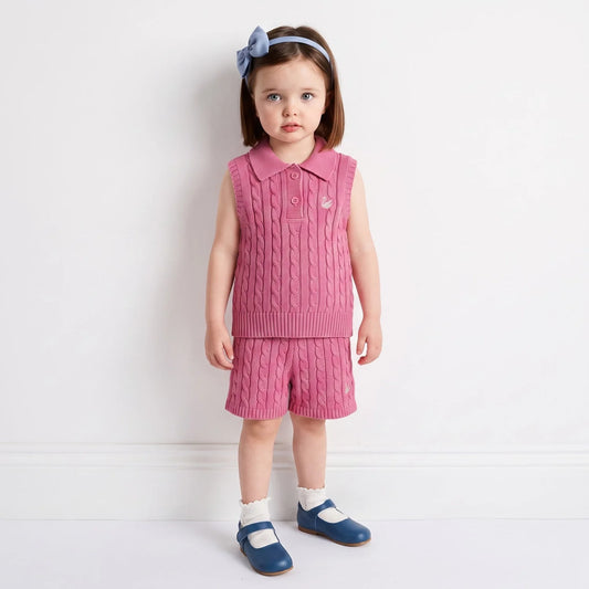 Rose pink cable-knit shorts on a child with ribbed waistband and textured knit