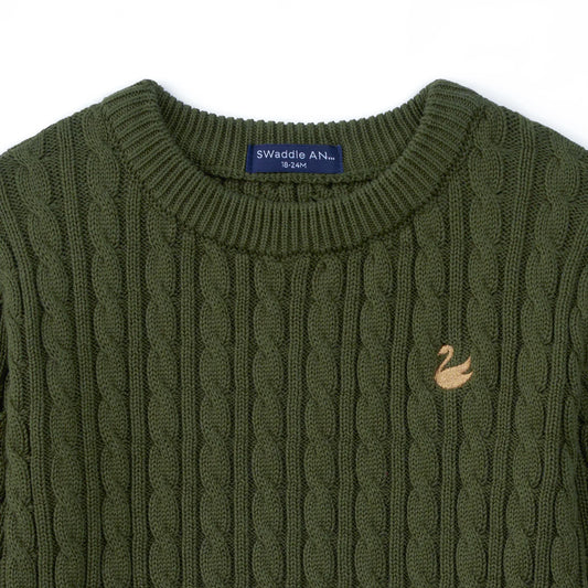 Forest green baby cable-knit sweater close-up, ribbed crew neck and stitched chest patch.