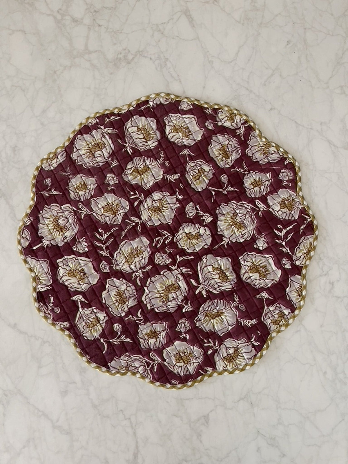 Quilted wine placemat with pale poppy print and scalloped edge