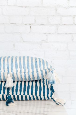 Stacked navy-blue and white striped pillows with tassel fringe
