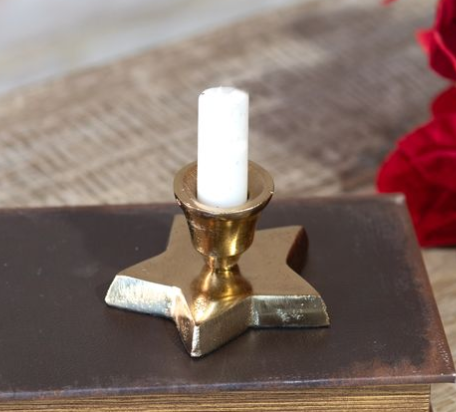 Gold star-shaped taper candle holder with a brass-tone cup and white candle