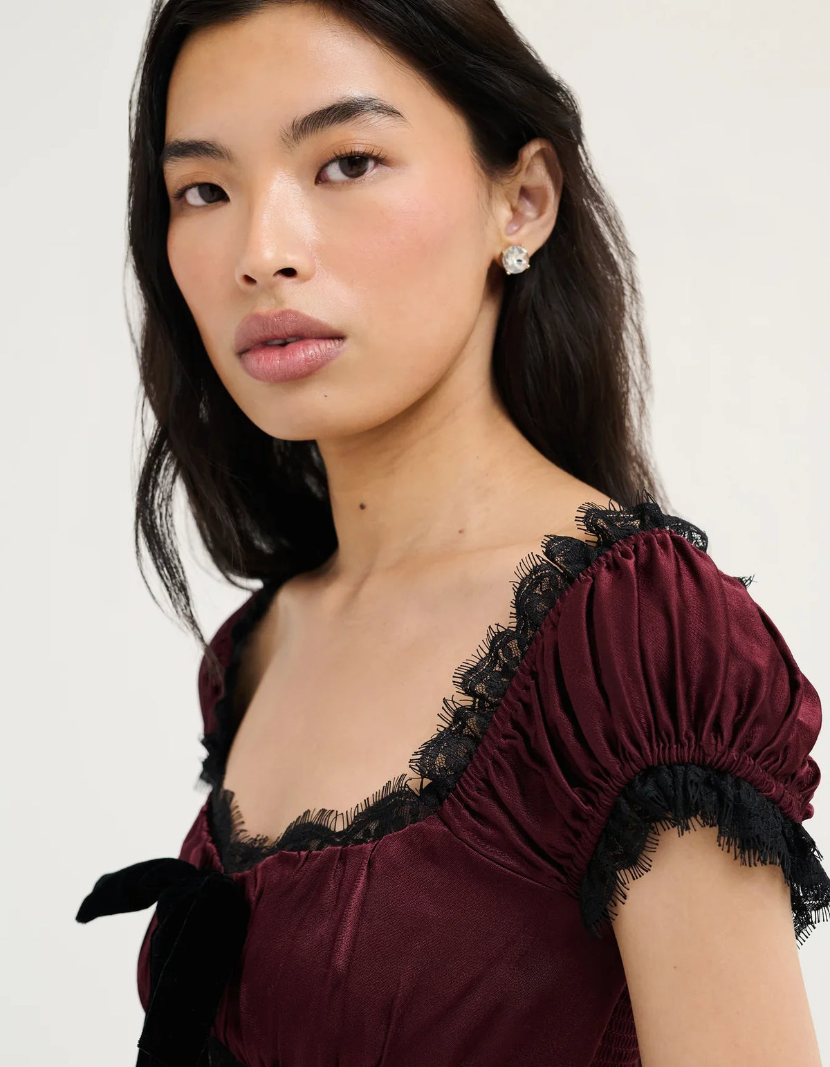 Burgundy midi dress shoulder close-up with black lace trim and ruffled puff sleeve