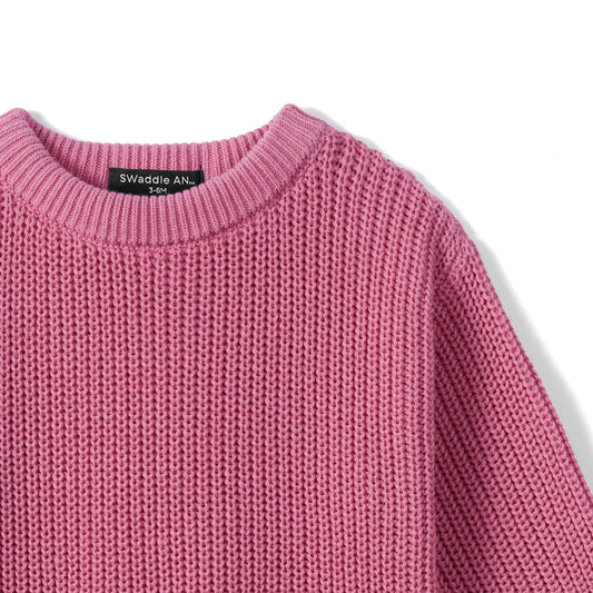 Rose pink knit baby romper neckline close-up with ribbed collar and textured fabric