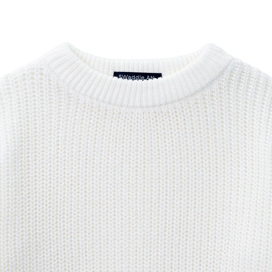 White knit baby sweater close-up of crew neck and brand label