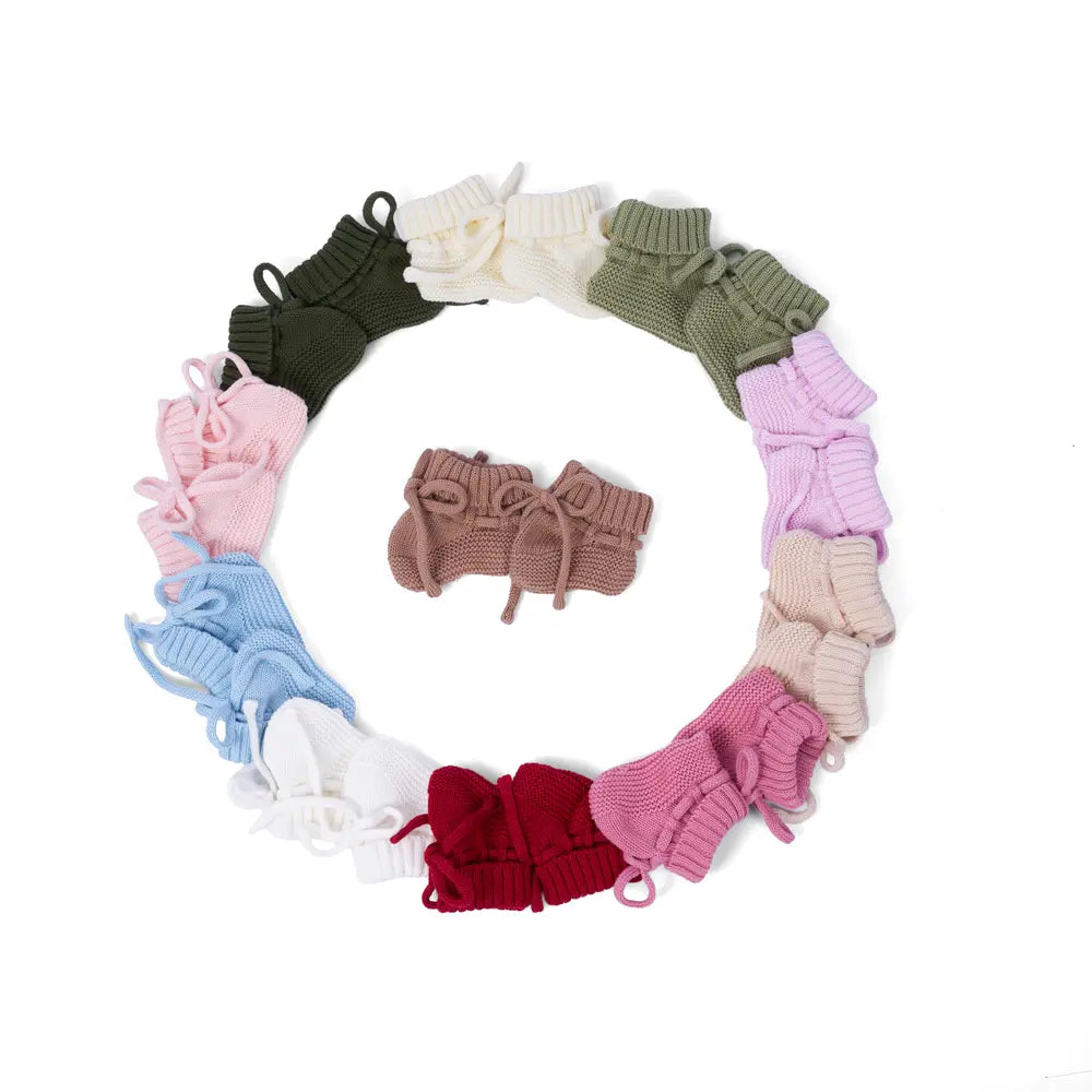 Circular wreath of knitted baby booties in mixed colors with a small center
