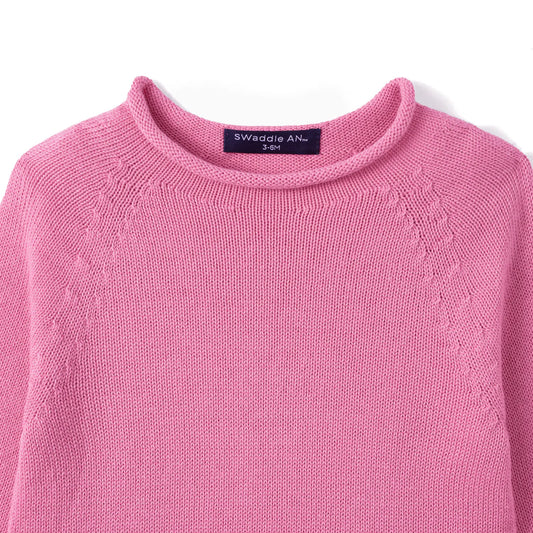 Rose pink knit baby rollneck sweater close-up of textured stitch and collar