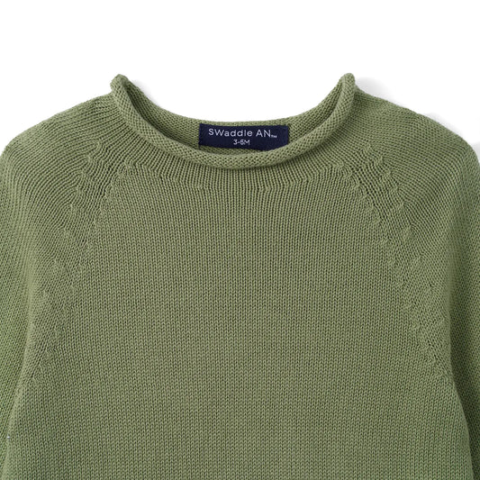 Sage green knit rollneck baby sweater close-up of ribbed collar and neck label