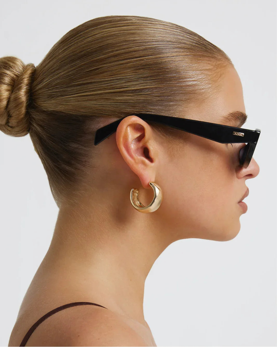 Polarized sunglasses with dark frame and brown lenses, side view close-up