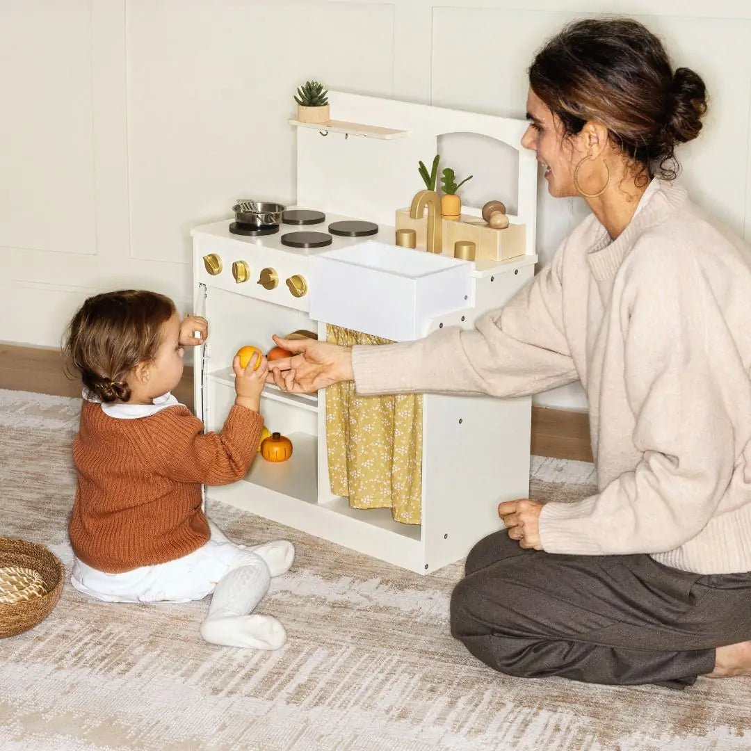 Wooden play kitchen with oven, sink, burners and toy produce
