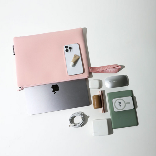 Pink laptop sleeve with flap open, showing interior and attached wrist strap