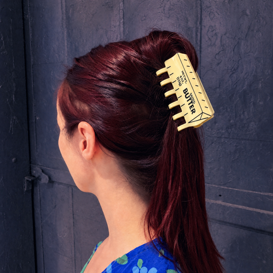 Yellow butter-themed hair claw clip holding burgundy hair in a high ponytail