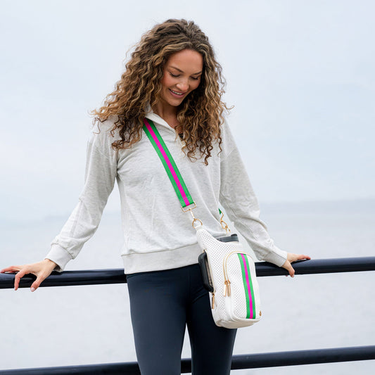 White striped crossbody HydroBag on a woman, attached to a green-and-pink shoulder strap