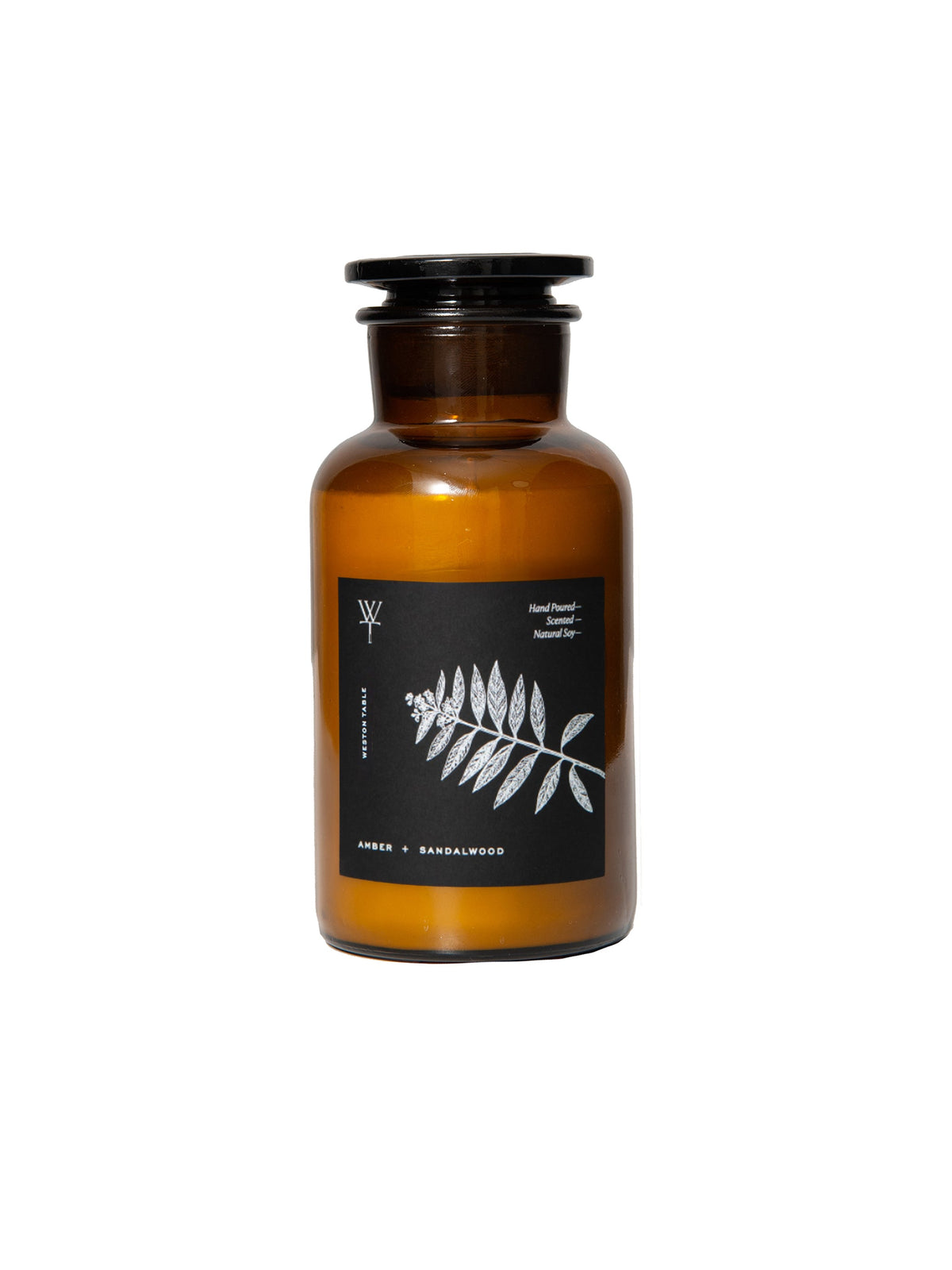 Amber glass apothecary candle in dark brown jar with black lid and botanical label