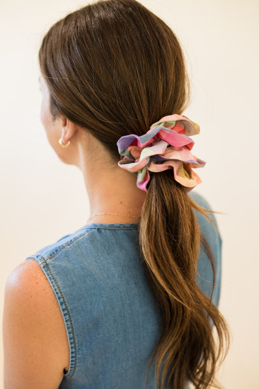Multicolor plaid hair scrunchie with bow on dark brown ponytail