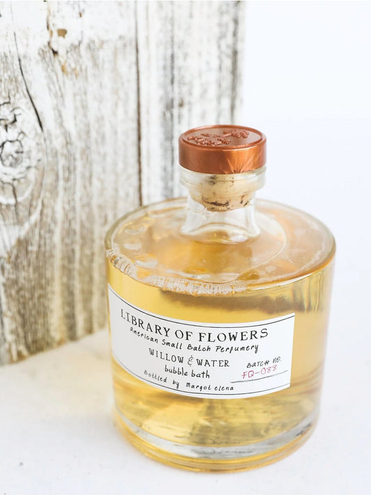 Amber bubble bath bottle with copper cap; frosted center label with 'Library of Flowers'.