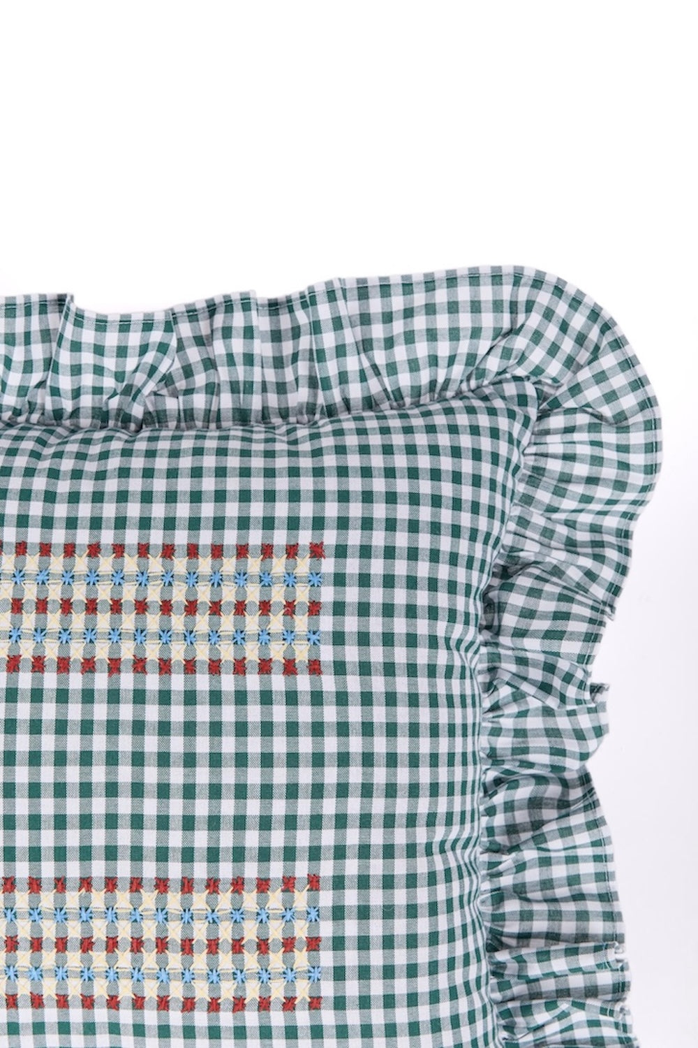 Gingham cushion close-up with ruffled side trim and embroidered horizontal stripe, check pattern