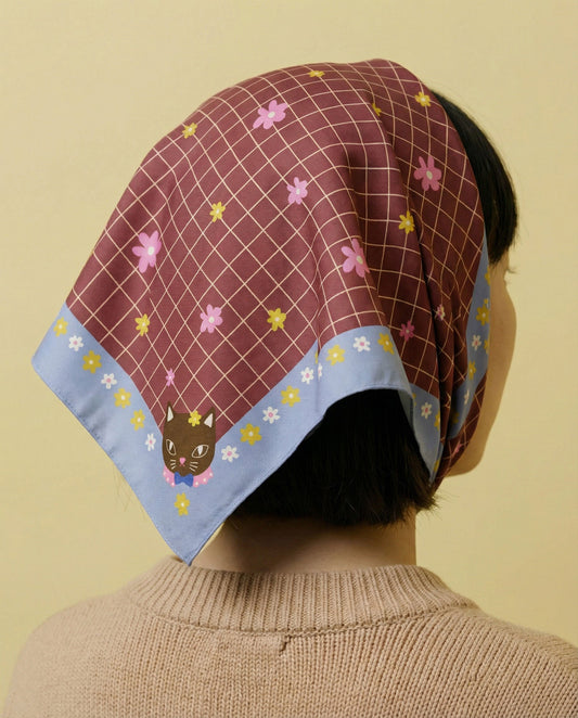 Cotton silk bandana worn on head; maroon grid with pink flowers and light blue border