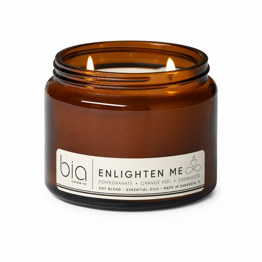 Amber glass jar soy blend candle with two flames and white ENLIGHTEN ME label