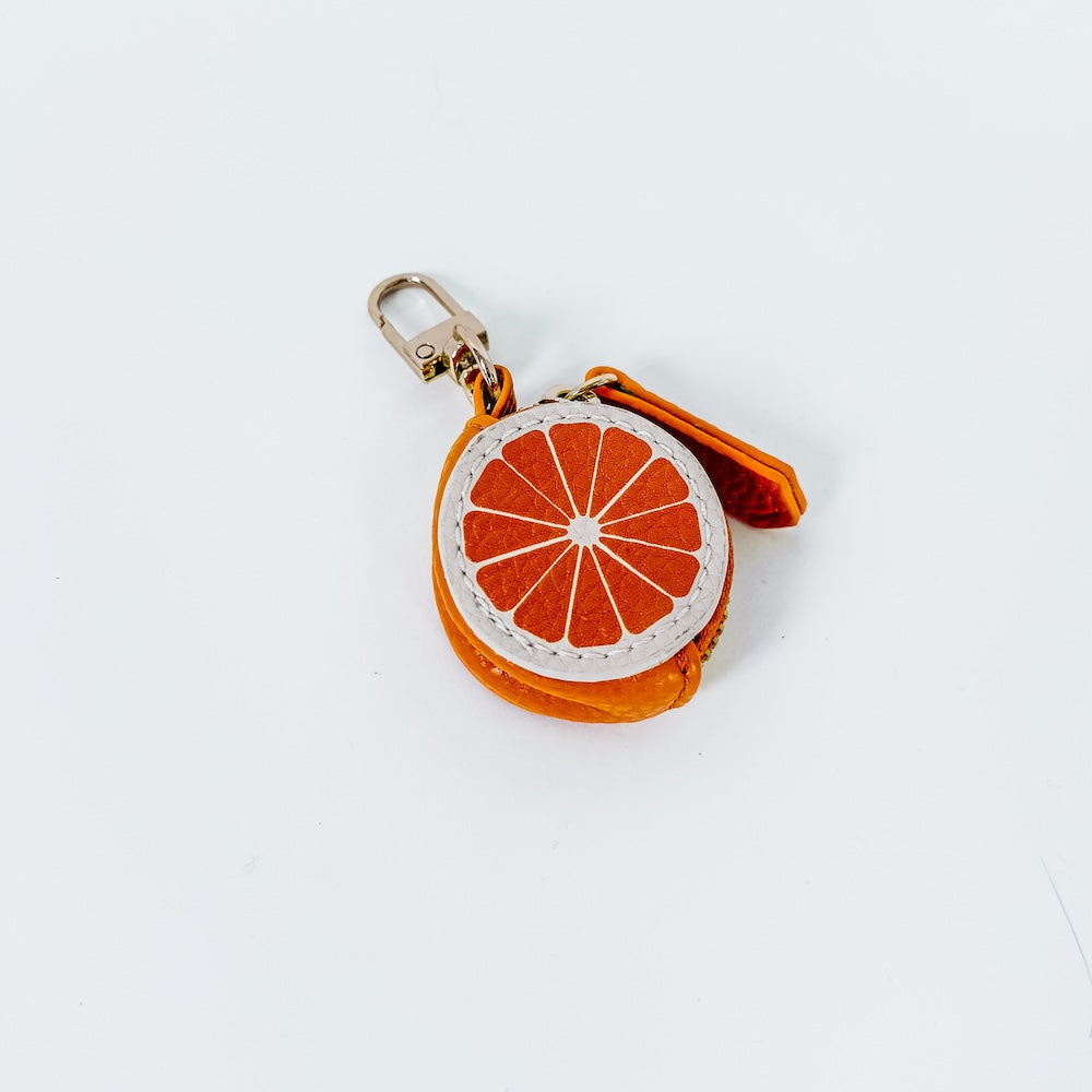 Orange slice-shaped fabric keychain charm with metal clasp and orange strap