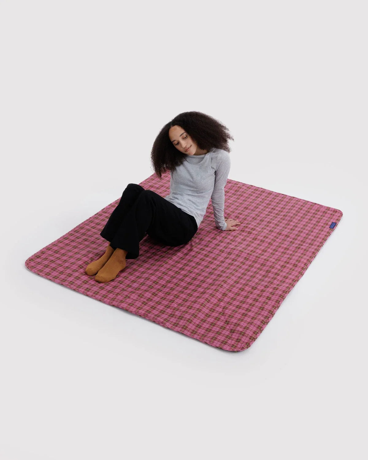 Baggu puffy picnic blanket spread flat in pink tartan plaid