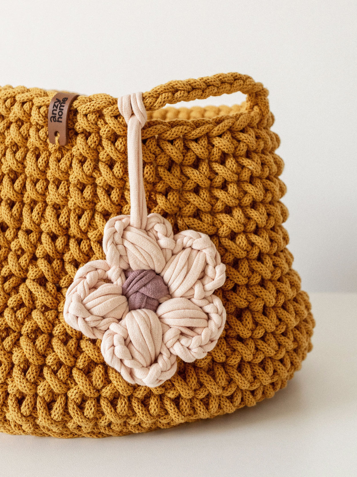 Toy nursery storage basket in mustard cord knit with braided handle and flower charm