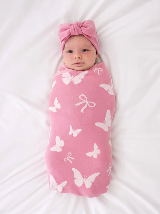 Pink butterfly-print baby blanket swaddle with matching head wrap and bow accents.
