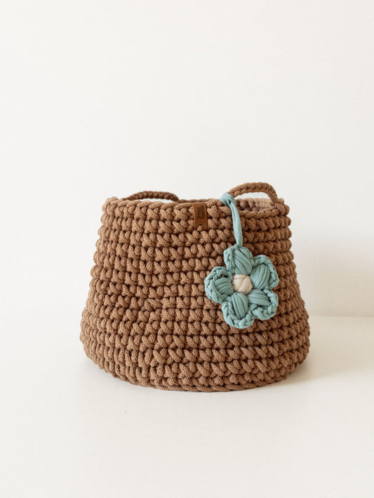 Brown crochet storage basket with teal flower applique and braided carry handles