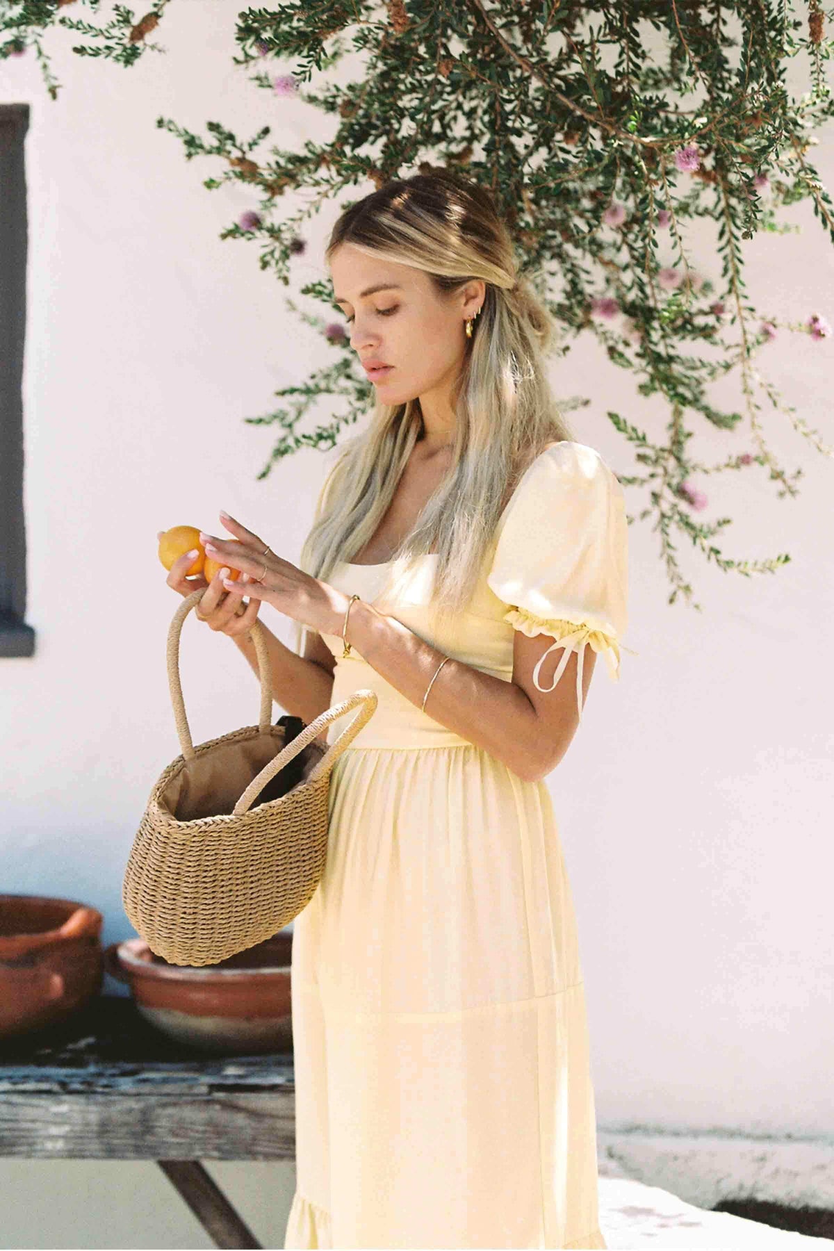 Soft yellow silk midi dress with square neckline, lace-trim puff sleeves, and tiers