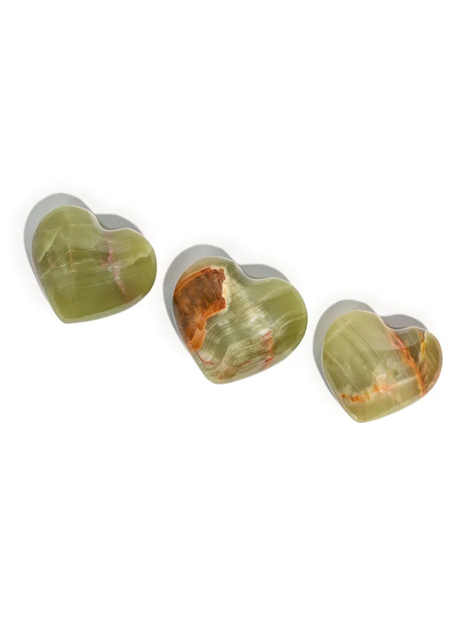Heart-shaped stone, translucent green with orange-brown and red veining, side angle