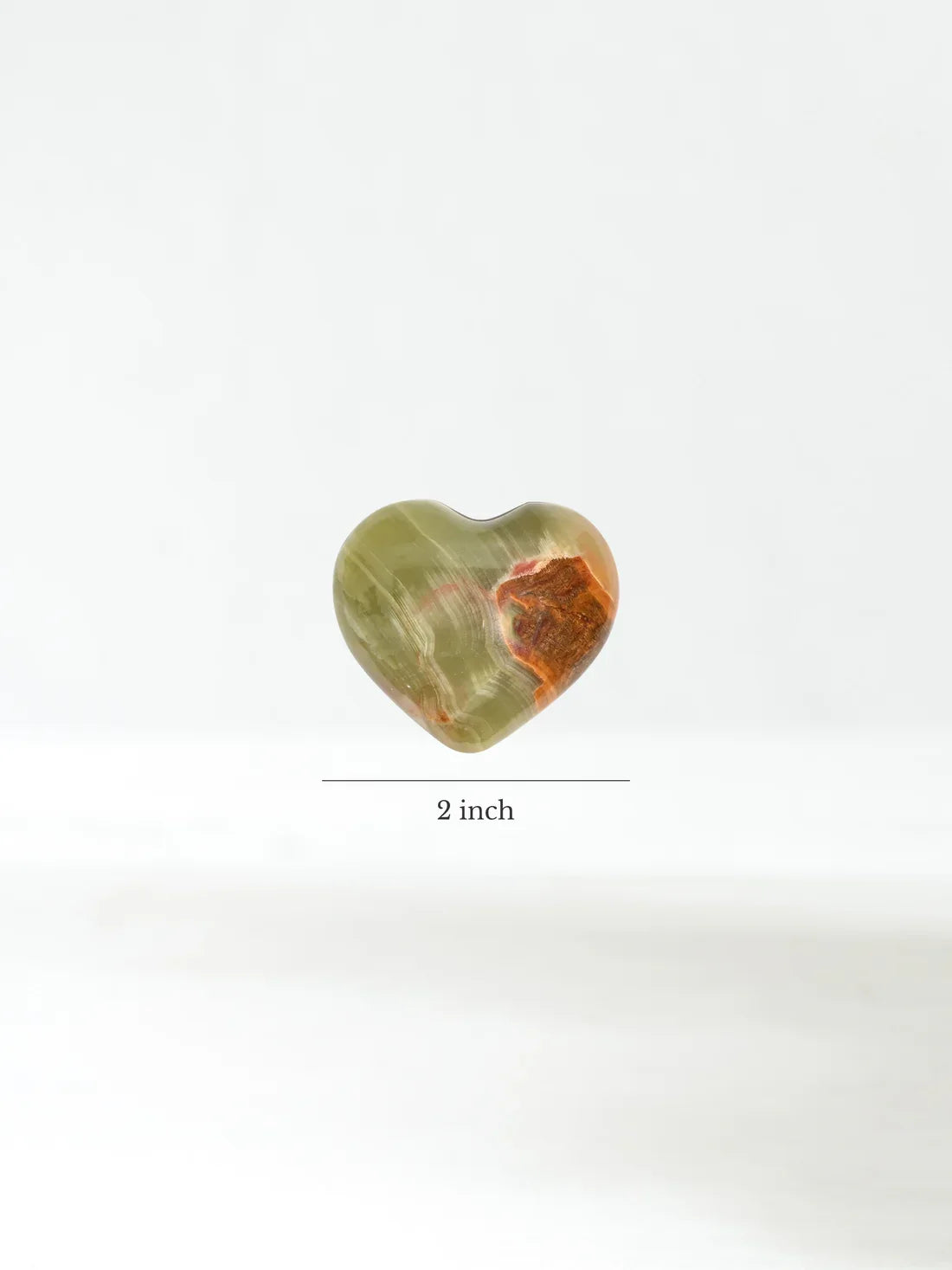 Heart-shaped stone, translucent green with orange-brown patch, 2 inch size