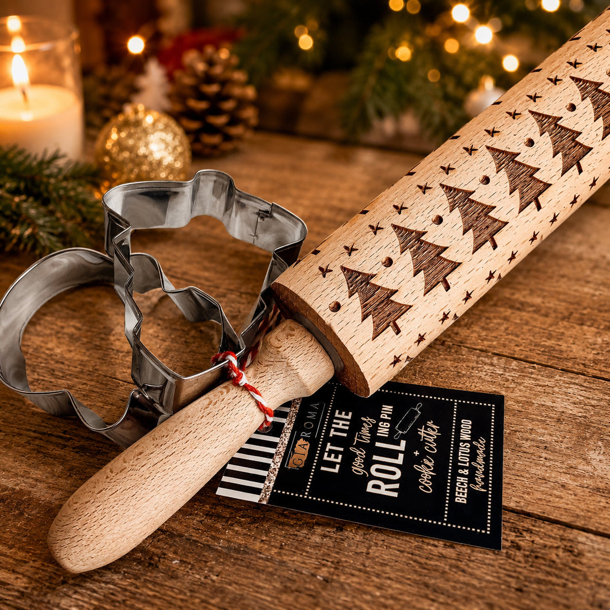Christmas rolling pin with starry tree pattern and metal cookie cutters on a table.