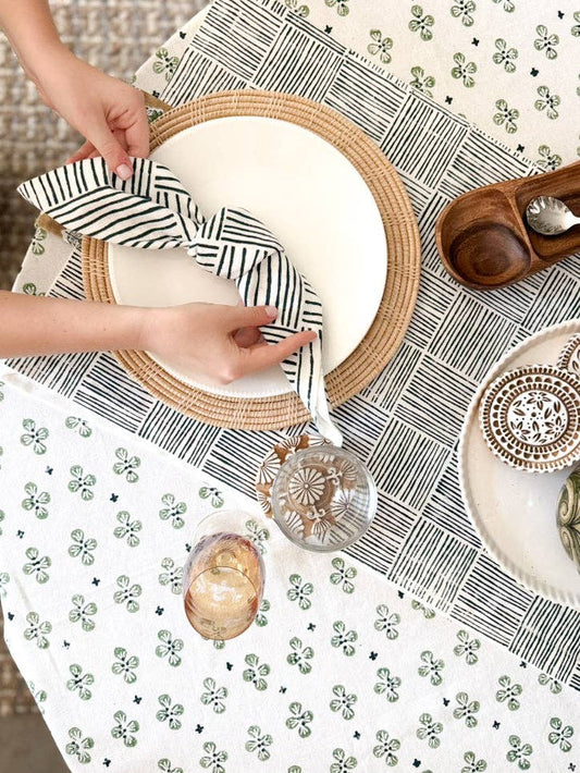Ivory table throw with green clover pattern and dark blue stripes, styled on table