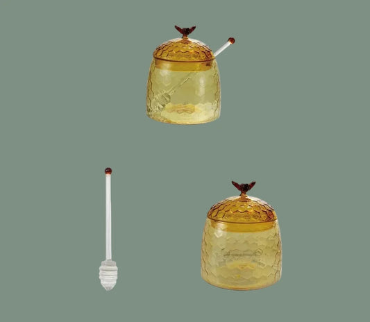 Glass honey jar with bee finial and honey dipper, amber-gold glass