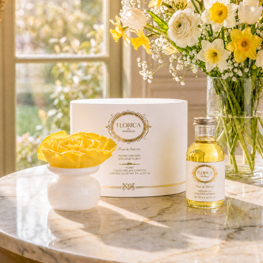 Floret diffuser bottle with yellow liquid and white ceramic flower base