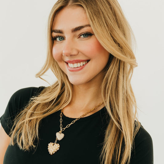 Gold chain heart pendant necklace with two pearl-like heart charms, dangling