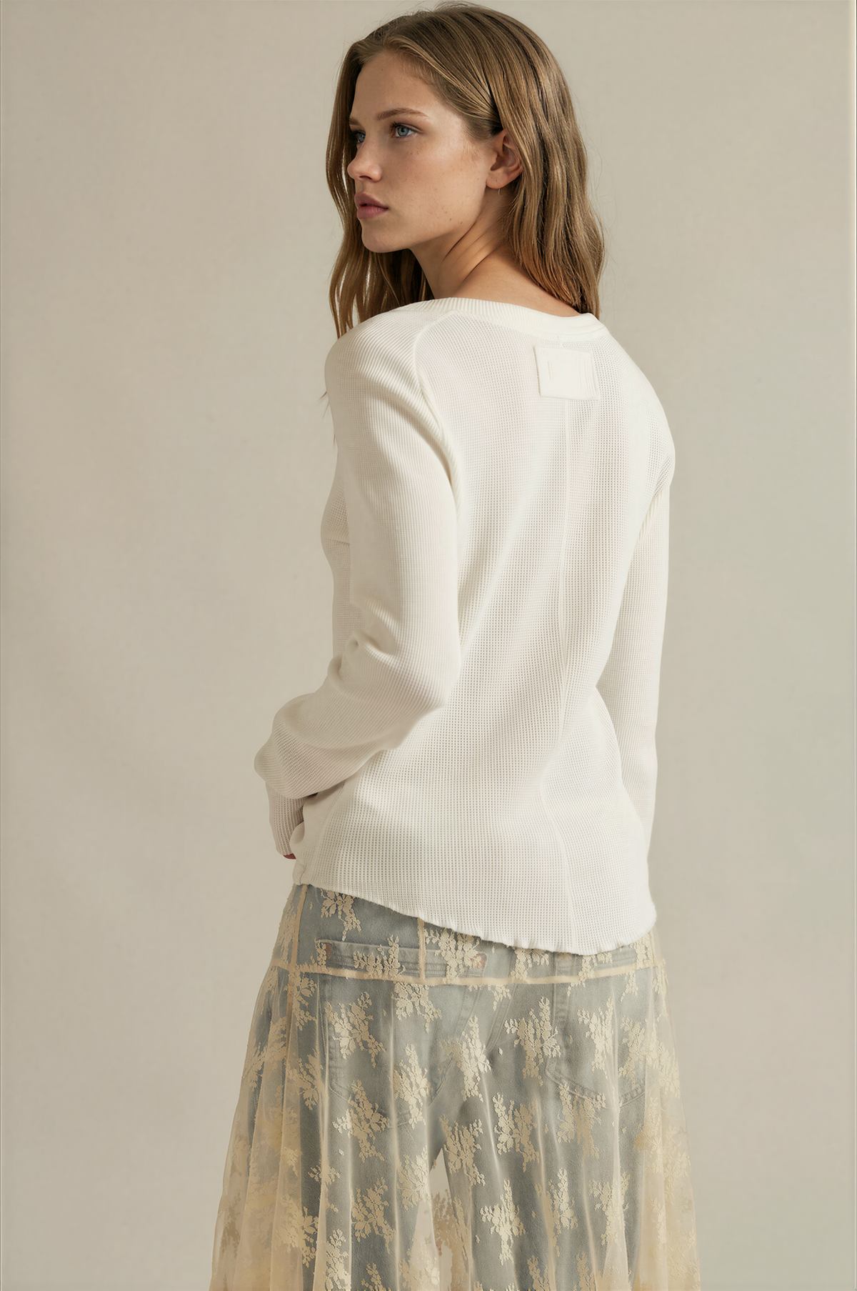 White long-sleeve crewneck tee back view with small square patch detail