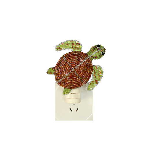 Sea turtle night light with green-and-orange bead details on white plug-in base