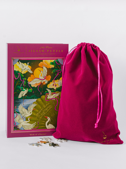 Jigsaw puzzle box with birds design and magenta drawstring pouch with loose pieces