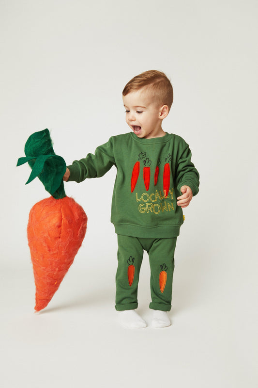 Green baby jogger pants with embroidered orange carrot motifs on the legs