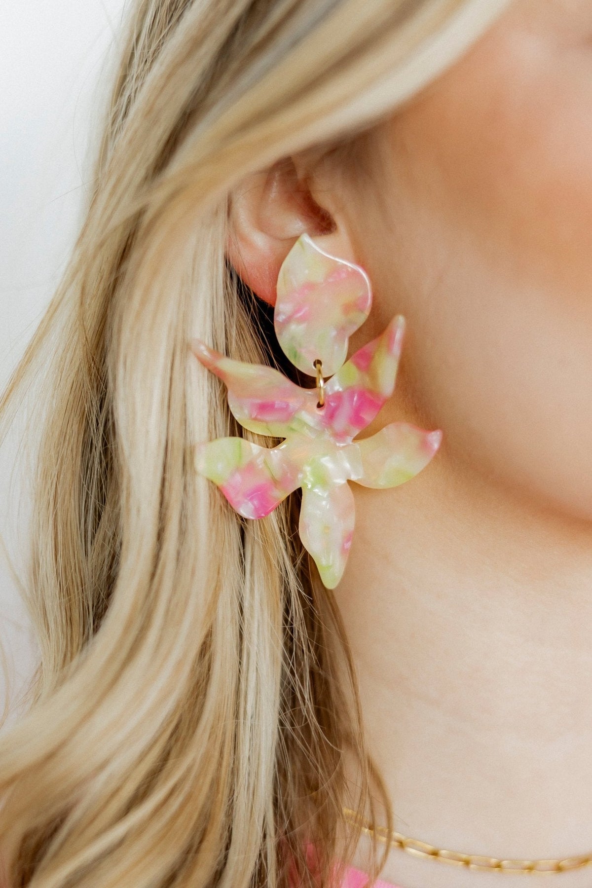 Floral earrings in pastel pink and lime with gold hoop hardware, side view