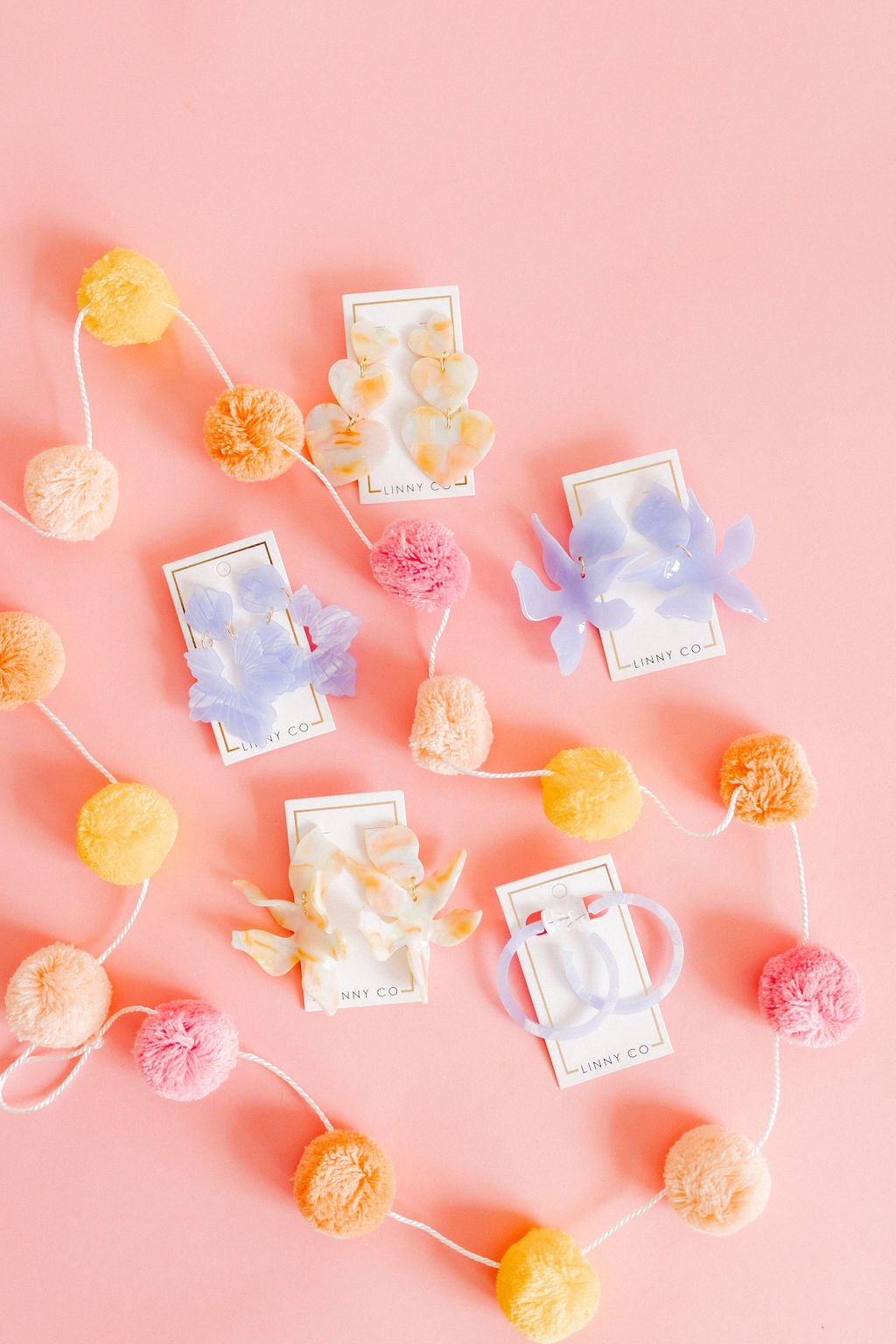 Floral statement earrings with pastel pom-pom accents and iridescent white petals
